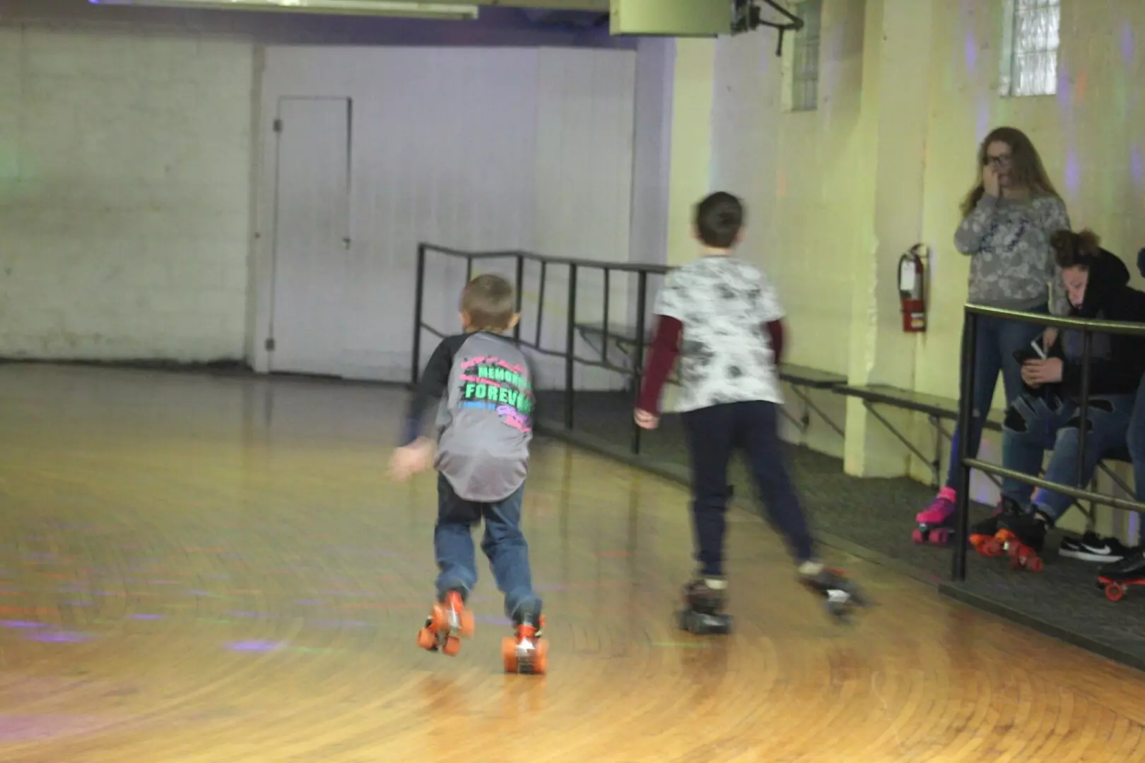 Two little boys racing on the roller rink