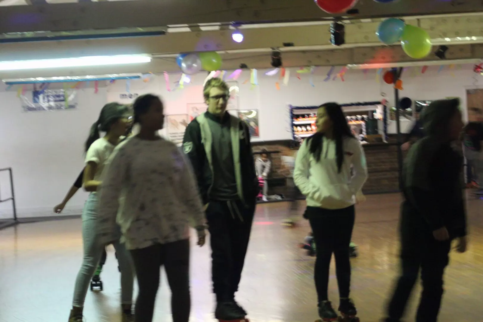 Group of friends strolling and skating on a roller rink